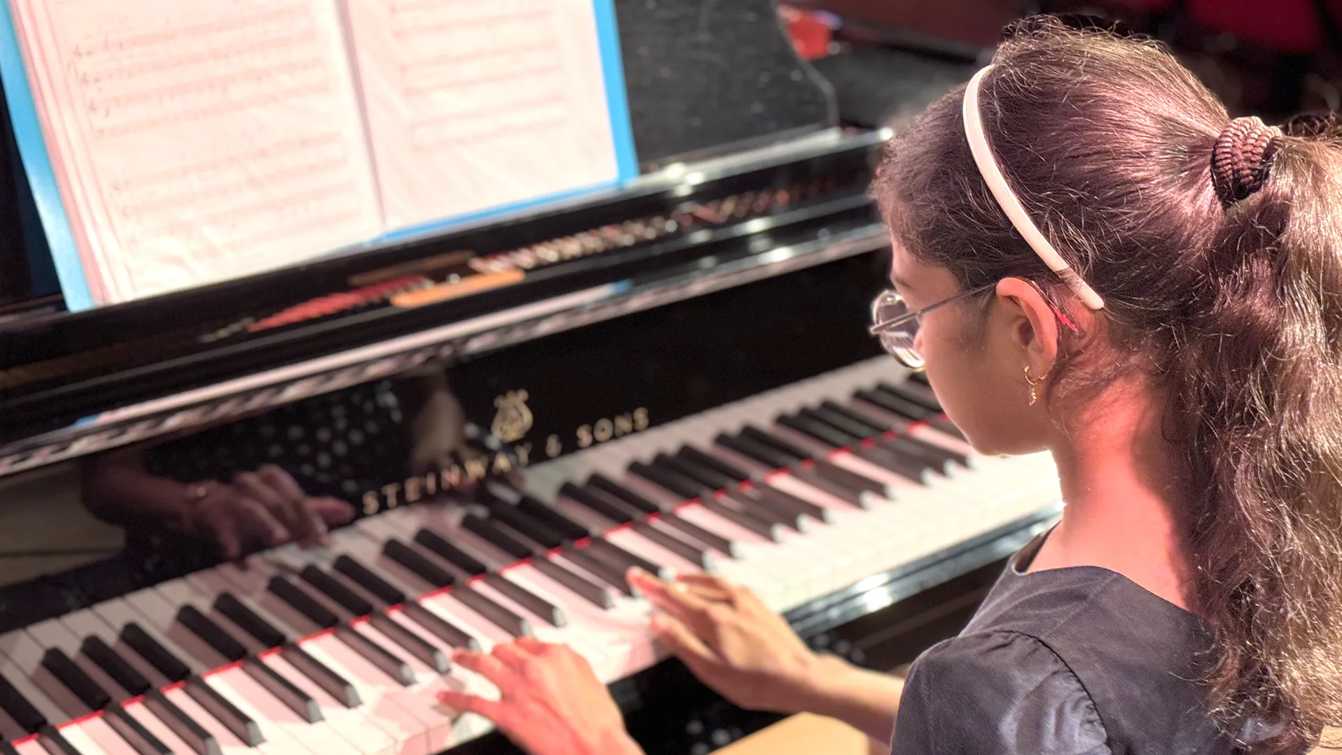 Élève de Vivalys jouant du piano sur scène à l’EJMA à Lausanne