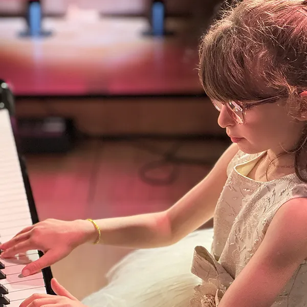 Élève de Vivalys jouant du piano sur scène à l’EJMA à Lausanne