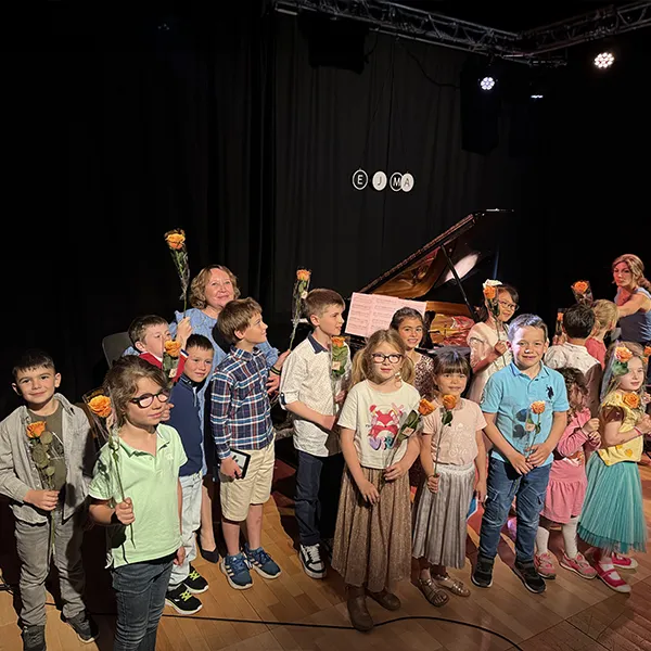 Enfants de l’école Vivalys recevant une rose après leur performance musicale