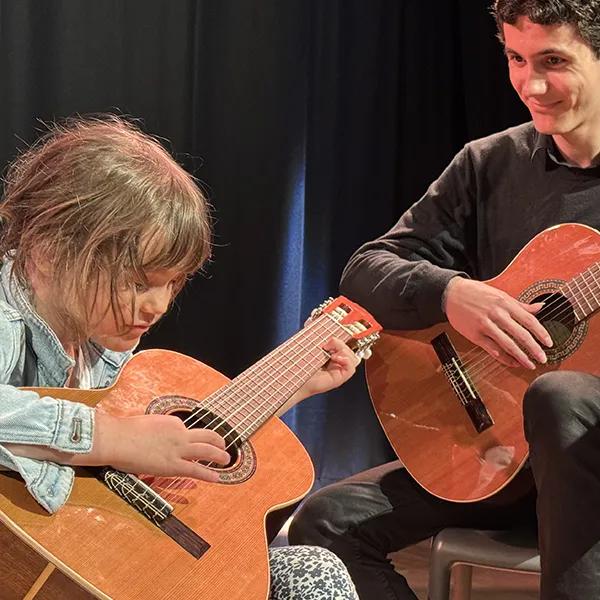 Professeur accompagnant un élève lors de son audition de guitare